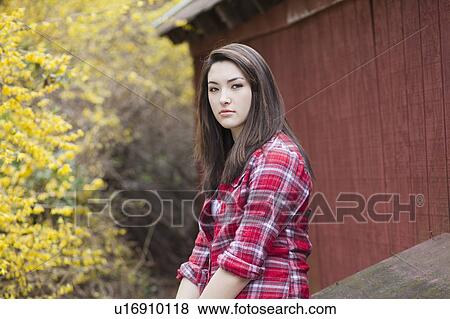 Stock Photo - Girl sitting in front of barn. Fotosearch