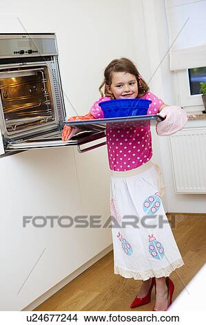 Girl taking a cake out of the oven View Large Photo Image Picture - Girl taking a cake out of the oven. Fotosearch