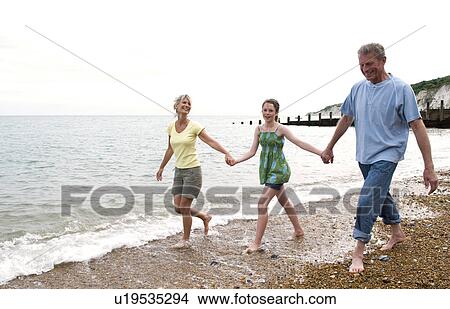 Girl walks on beach with grandparents View Large Photo Image Picture - Girl walks on beach with grandparents. Fotosearch