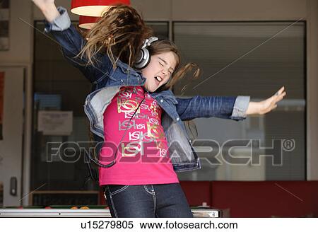 Stock Photography - Girl wearing headphones jumping. Fotosearch