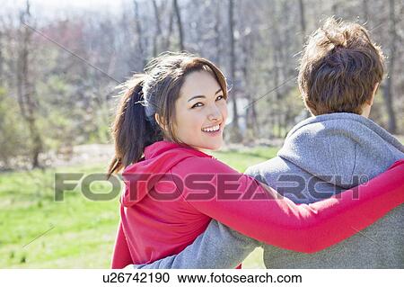 Stock Image - Girl with arm around boy. Fotosearch