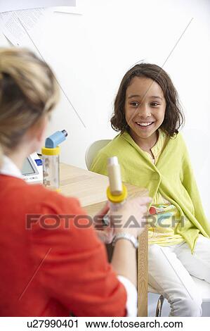 Girl with doctor showing asthma inhaler View Large Photo Image Stock Image - Girl with doctor showing asthma inhaler. Fotosearch