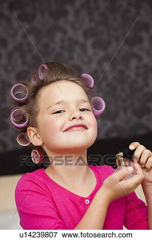 Girl with hair curler spraying perfume View Large Photo Image Stock Photo - Girl with hair curler spraying perfume. Fotosearch