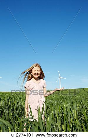 Stock Image - Girl with wind turbine in hand. Fotosearch