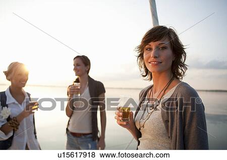 Stock Photo - Girls drinking beer on boat. Fotosearch