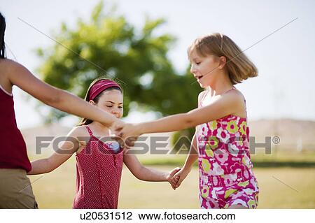 Girls holding hands dancing in a circle View Large Photo Image Stock Image - Girls holding hands dancing in a circle. Fotosearch