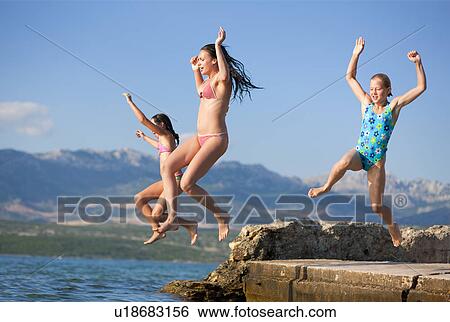 Girls jumping into water View Large Photo Image Stock Photograph - Girls jumping into water. Fotosearch