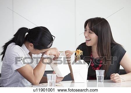 Stock Image - Girls laughing during lunch break. Fotosearch