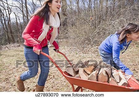 Stock Image - Girls running with wheelbarrow. Fotosearch