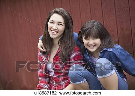 Girls sitting by barn View Large Photo Image Stock Image - Girls sitting by barn. Fotosearch