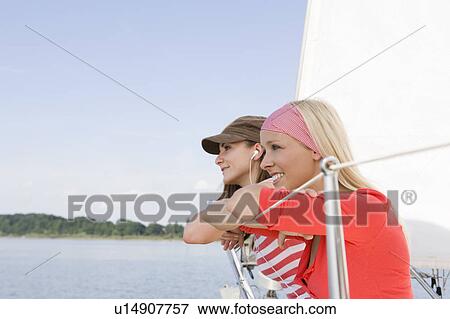 Stock Photo - Girls sitting on boat. Fotosearch