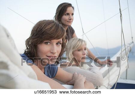 Stock Image - Girls standing on sail. Fotosearch