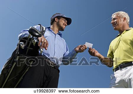 Stock Photo - Golfer giving his card to the caddy. Fotosearch