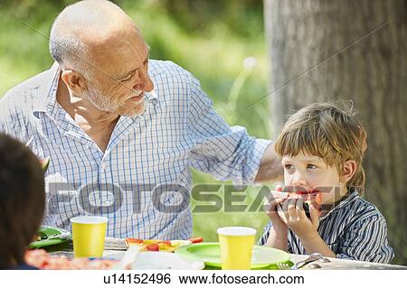 Stock Photograph - Grandfather with grandson at picnic. Fotosearch