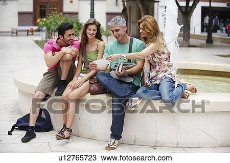 Stock Image - Group of tourists by fountain. Fotosearch