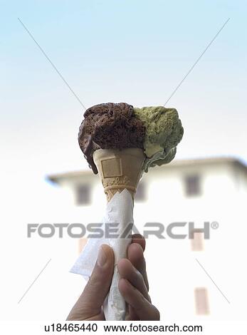 Stock Image - Hand holding ice cream. Fotosearch