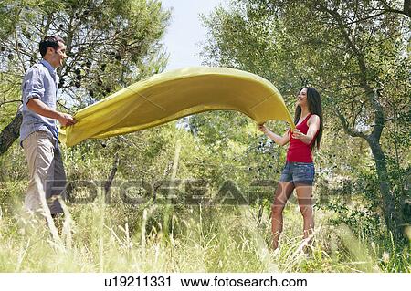 Happy couple laying out picnic blanket View Large Photo Image Stock Image - Happy couple laying out picnic blanket. Fotosearch