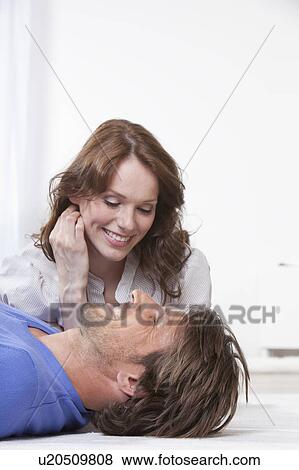 Happy couple lying on rug View Large Photo Image Stock Photo - Happy couple lying on rug. Fotosearch