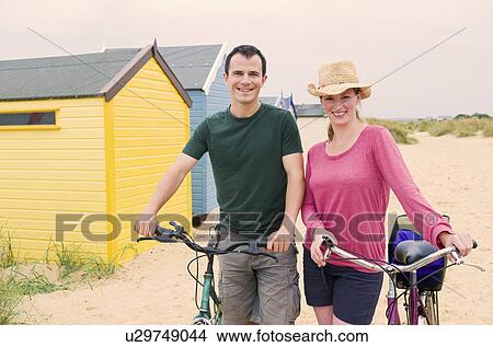 Picture - Happy couple on beach with bicycles. Fotosearch
