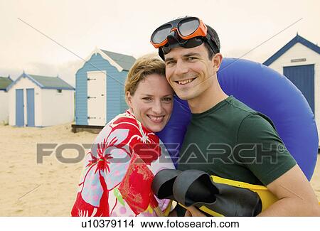 Happy couple prepare for fun on beach View Large Photo Image Picture - Happy couple prepare for fun on beach. Fotosearch