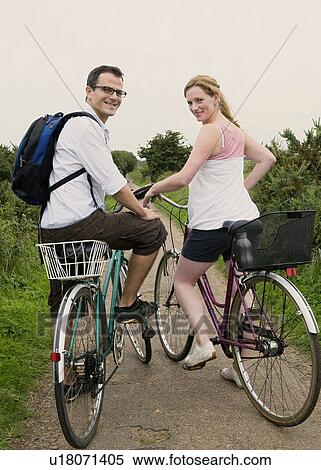 Happy couple prepare to bicycle View Large Photo Image Stock Photography - Happy couple prepare to bicycle. Fotosearch