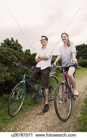 Stock Image - Happy couple relax on bikes. Fotosearch