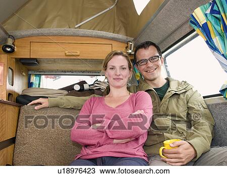 Happy couple sit in camper van View Large Photo Image Stock Image - Happy couple sit in camper van. Fotosearch