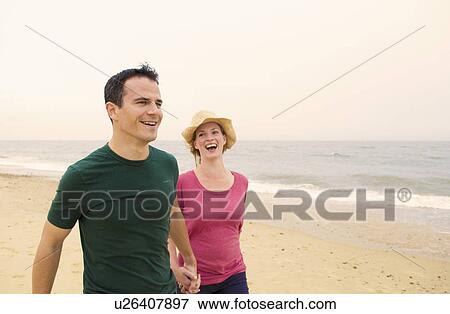 Happy couple walk on beach View Large Photo Image Stock Photo - Happy couple walk on beach. Fotosearch