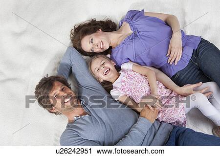 Happy family lying on rug View Large Photo Image Stock Image - Happy family lying on rug. Fotosearch