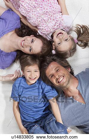 Stock Photography - Happy family lying on rug. Fotosearch