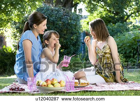 Happy mother and daughters at picnic View Large Photo Image Stock Photo - Happy mother and daughters at picnic. Fotosearch