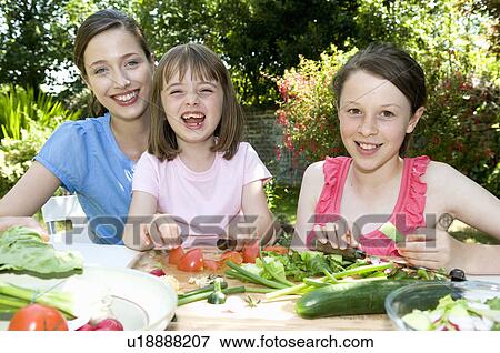Happy mother and daughters prepare food View Large Photo Image Stock Photo - Happy mother and daughters prepare food. Fotosearch