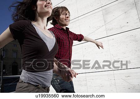 Stock Image - Happy young couple jumping. Fotosearch