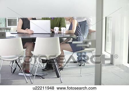 Hidden workmates looking at laptop View Large Photo Image Stock Photo - Hidden workmates looking at laptop. Fotosearch