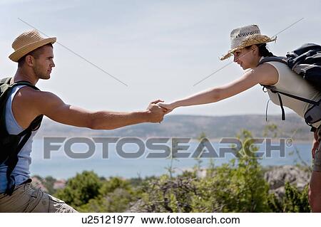 Hikers assisting each other View Large Photo Image Stock Photo - Hikers assisting each other. Fotosearch