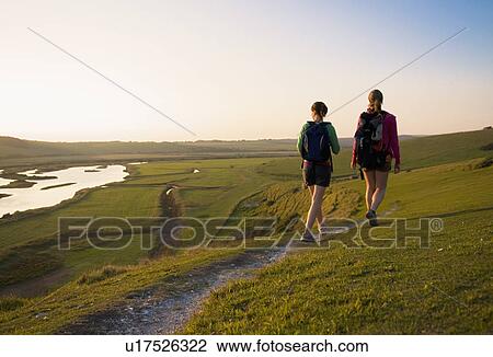 Hikers walk towards sunset View Large Photo Image Stock Image - Hikers walk towards sunset. Fotosearch