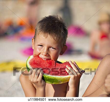 Kids eating watermelon at the beach View Large Photo Image Stock Image - Kids eating watermelon at the beach. Fotosearch