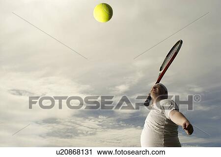 Stock Image - Large tennis player with giant racquet. Fotosearch