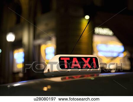 Stock Photo - Lit Taxi sign at night. Fotosearch
