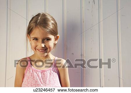 Little girl in front of a wooden wall View Large Photo Image Stock Photo - Little girl in front of a wooden wall. Fotosearch