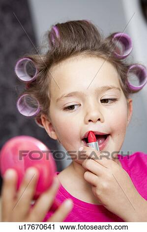 Stock Image - Little Girl using lipstick. Fotosearch