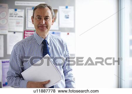 Male Medical consultant holding papers View Large Photo Image Stock Photo - Male Medical consultant holding papers. Fotosearch