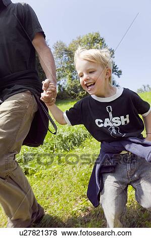 Man and boy running down a hill View Large Photo Image Stock Photo - Man and boy running down a hill. Fotosearch