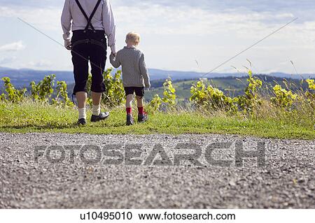Stock Image - Man and boy wandering in the foothills. Fotosearch