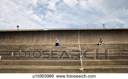 Man and woman sitting apart on steps View Large Photo Image Stock Photo - Man and woman sitting apart on steps. Fotosearch