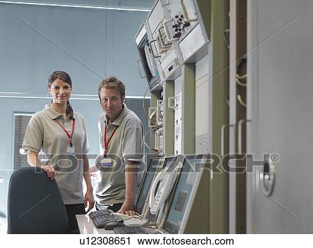 Man and woman work at control desk View Large Photo Image Stock Image - Man and woman work at control desk. Fotosearch