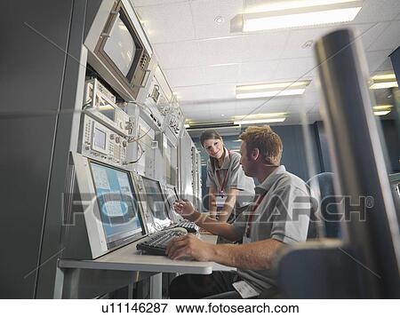 Man and woman work at control desk View Large Photo Image Stock Photo - Man and woman work at control desk. Fotosearch