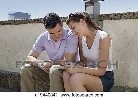Stock Image - Man and woman writing postcard. Fotosearch