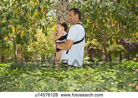 Stock Photo - Man carrying baby in park. Fotosearch