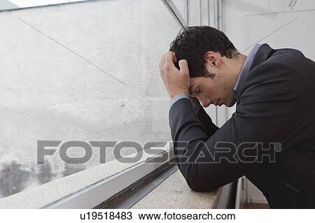 Stock Image - Man contemplating after a days work. Fotosearch